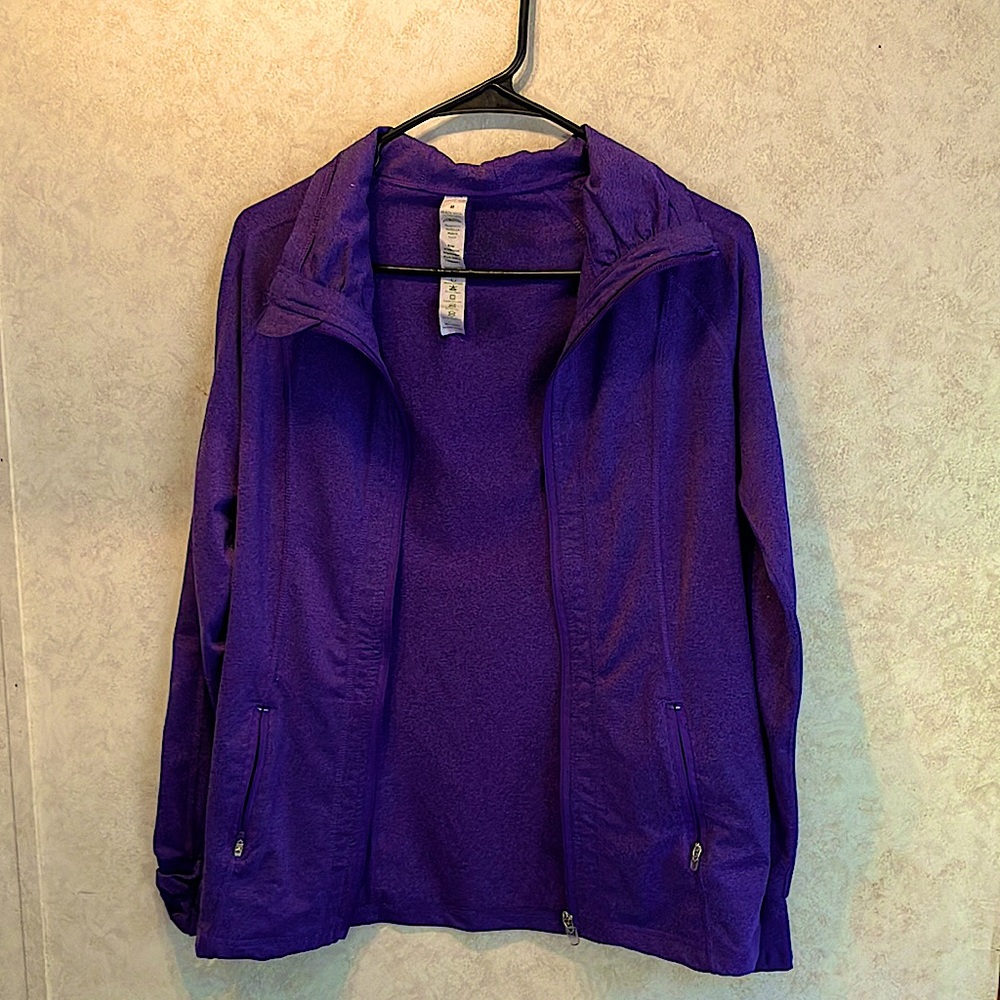 Purple lightweight running/athletic jacket with thump holes built in.